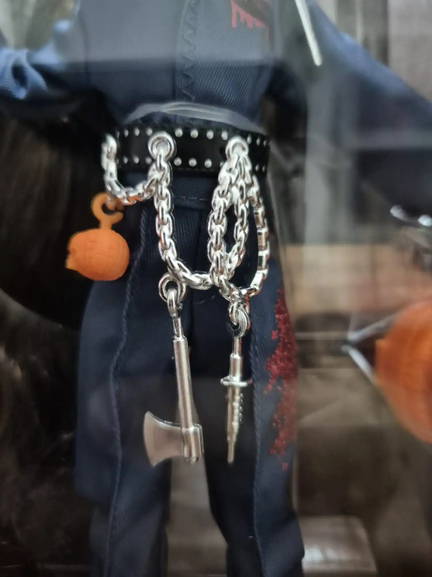 Detalle del cinturón con cadenas, hacha y amuletos de la muñeca Monster High Skullector Michael Myers.
